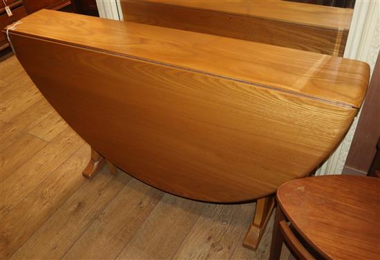 An Ercol light elm oval drop-leaf dining table, W.130cm